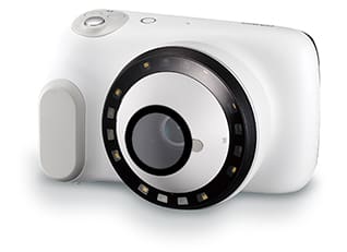 The white dermatological camera from CASIO with ring light around the large lens and a protective film on it
