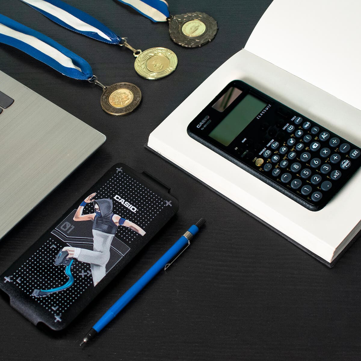 The Sport Case 2023 by Aleksandar Georgiev with a Paralympics sprinter, next to it the calculator is on a notebook and three sports medals