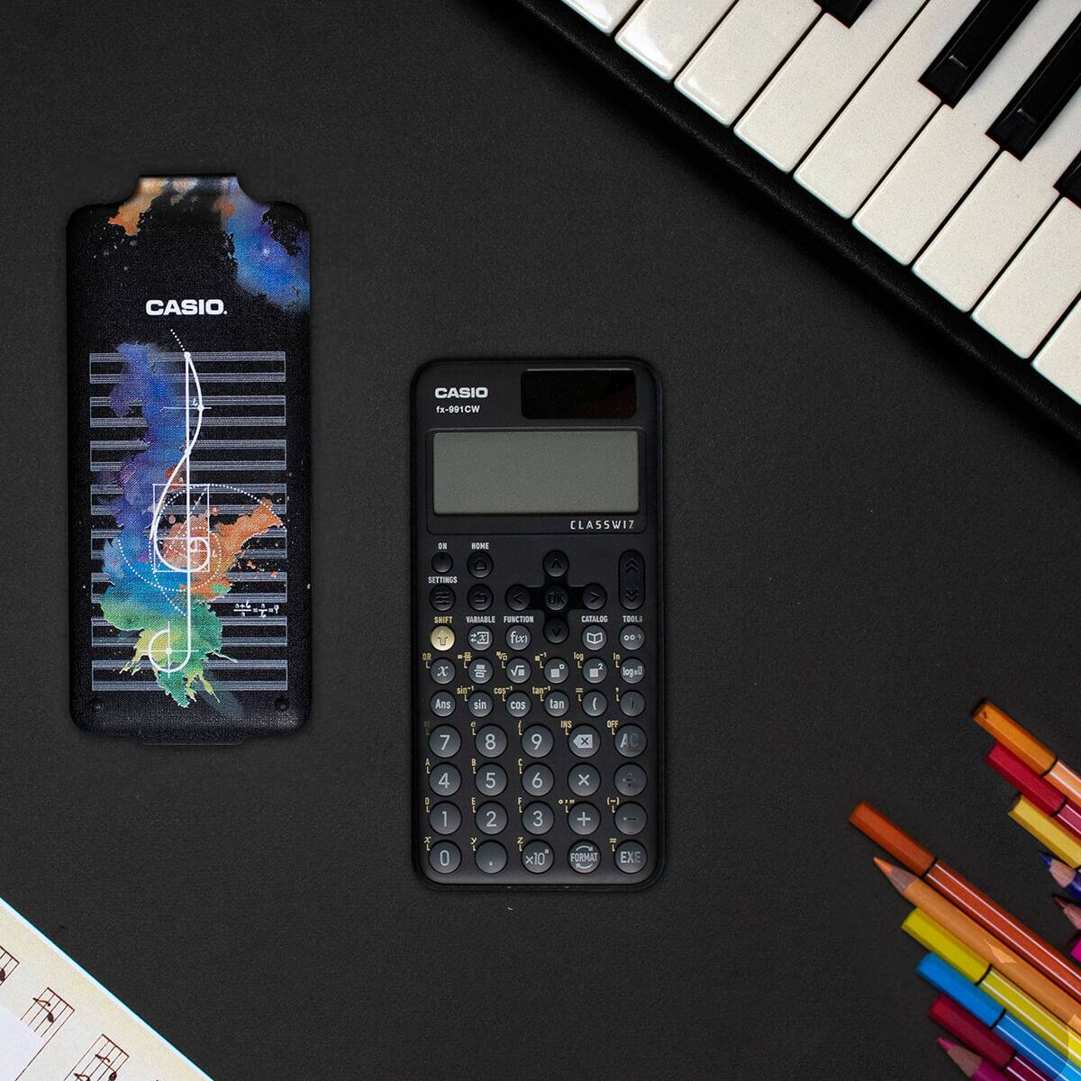 A CASIO school and graphic calculator in black on a desk with the Music Case with sheet music and splashes of colour on it