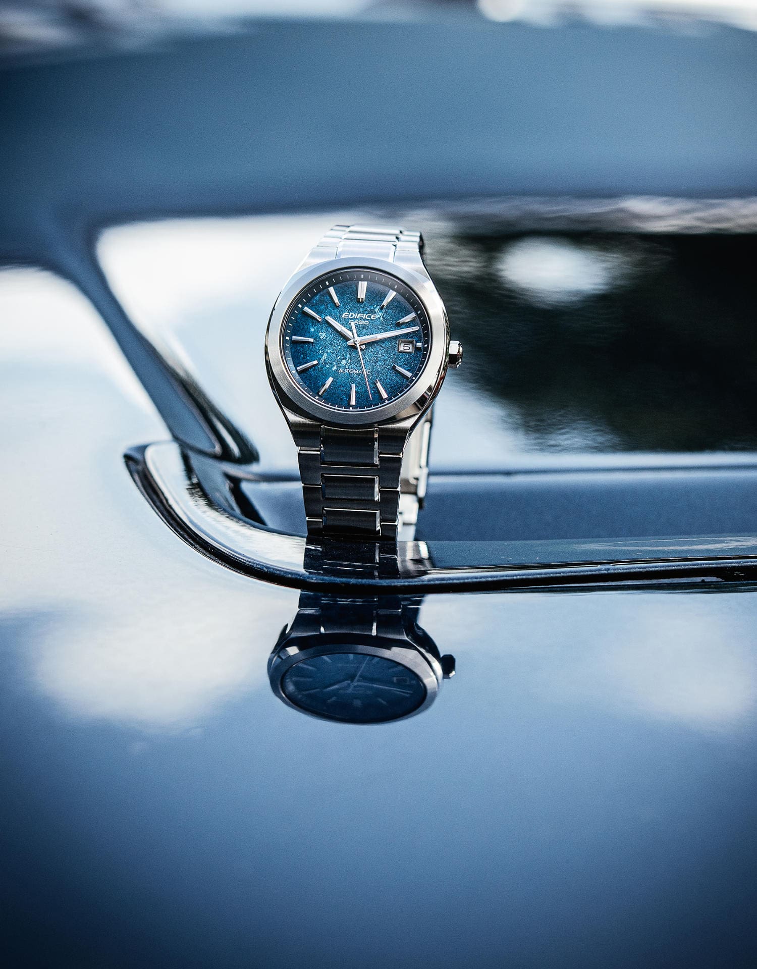 Close-up of the EFK-200D-1A analogue watch on a shimmering blue bonnet