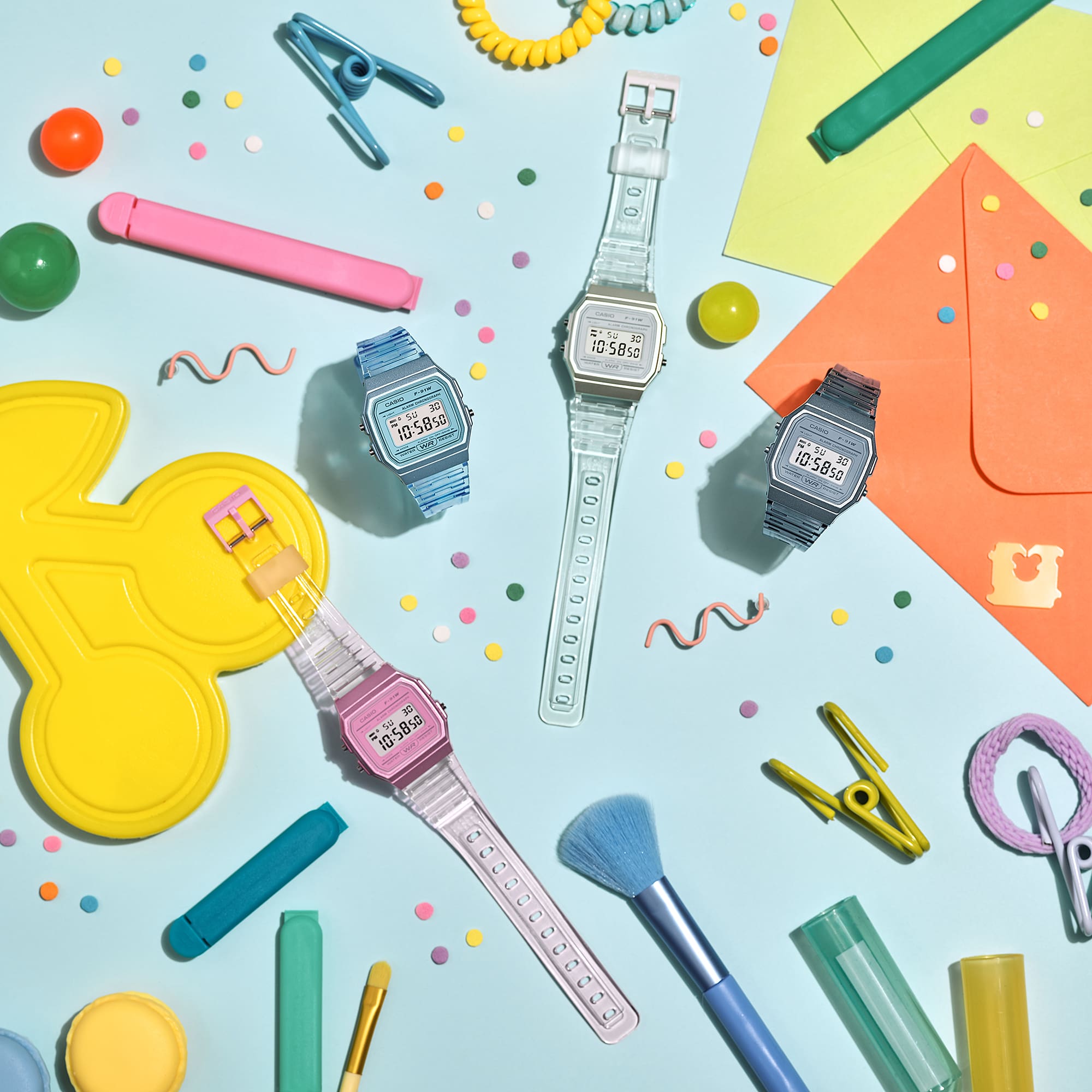 The various F-91WS colour models arranged on a colourful desk. The picture links to the light blue F-91WS-2 wristwatch.