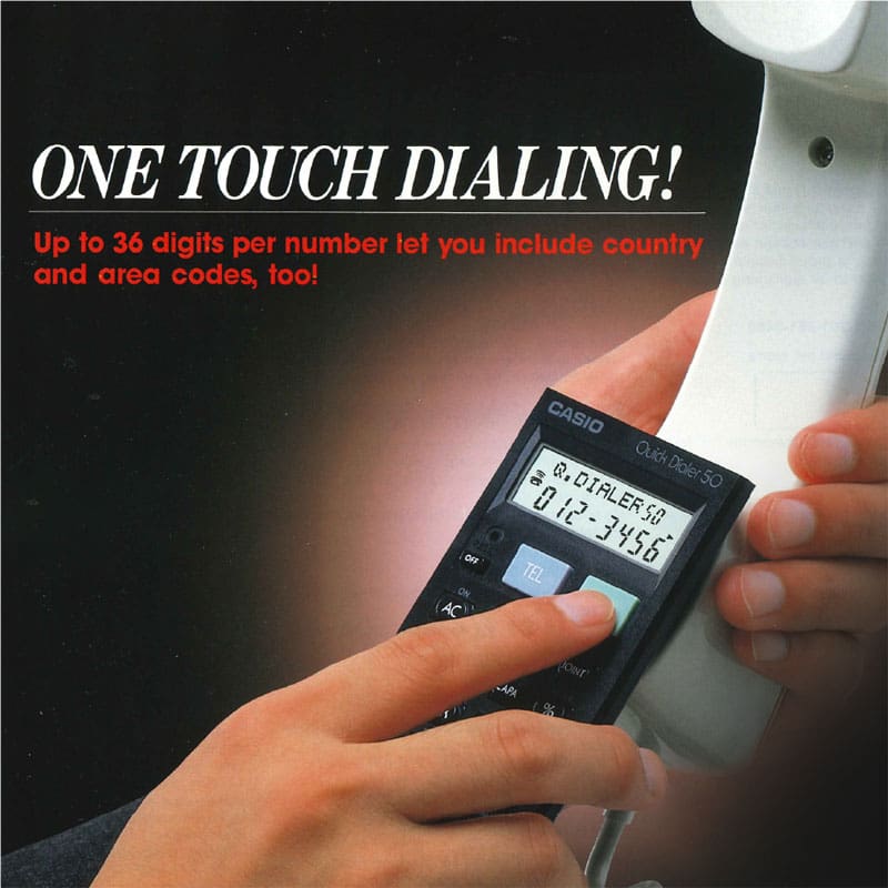 Une calculatrice compacte noire est tenue contre un téléphone blanc.