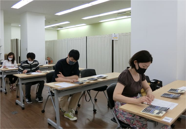 Différentes personnes dans un bureau testent les premiers prototypes de calculatrice ergonomique
