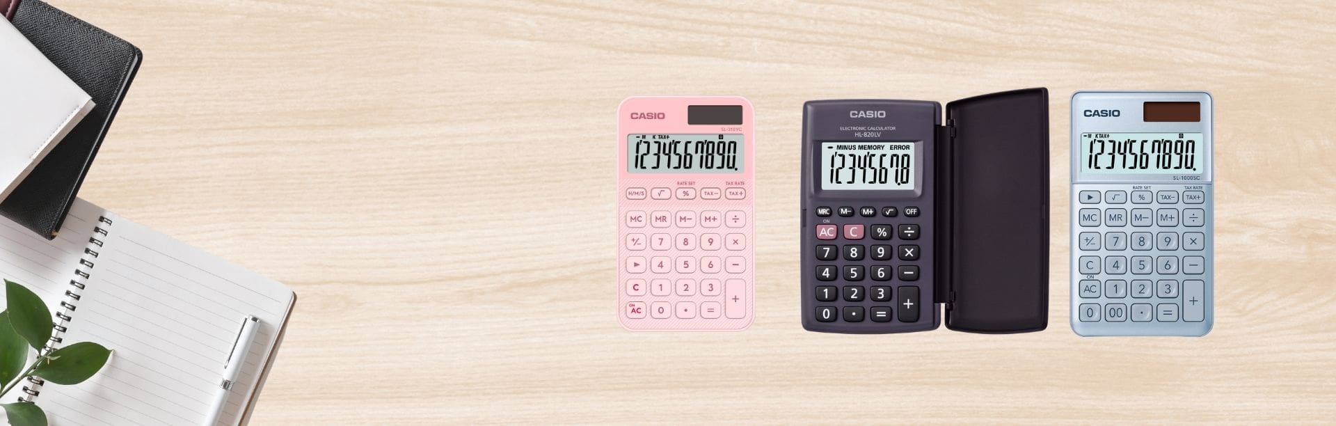 Quatre calculatrices de bureau CASIO classiques, rose, noire à couvercle à charnière et grise, posées sur un bureau clair..