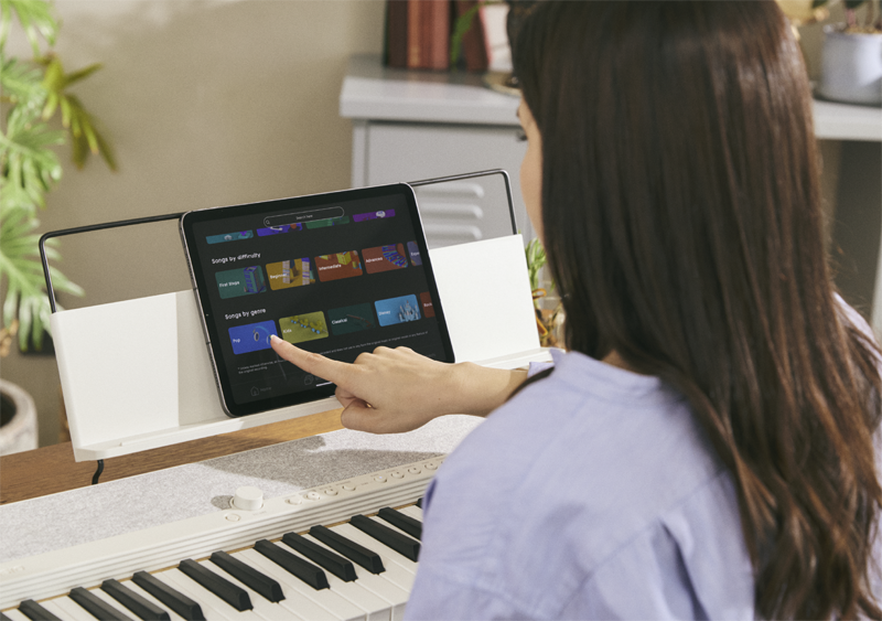 Vue par-dessus l'épaule d'une femme utilisant l'application sur une tablette.