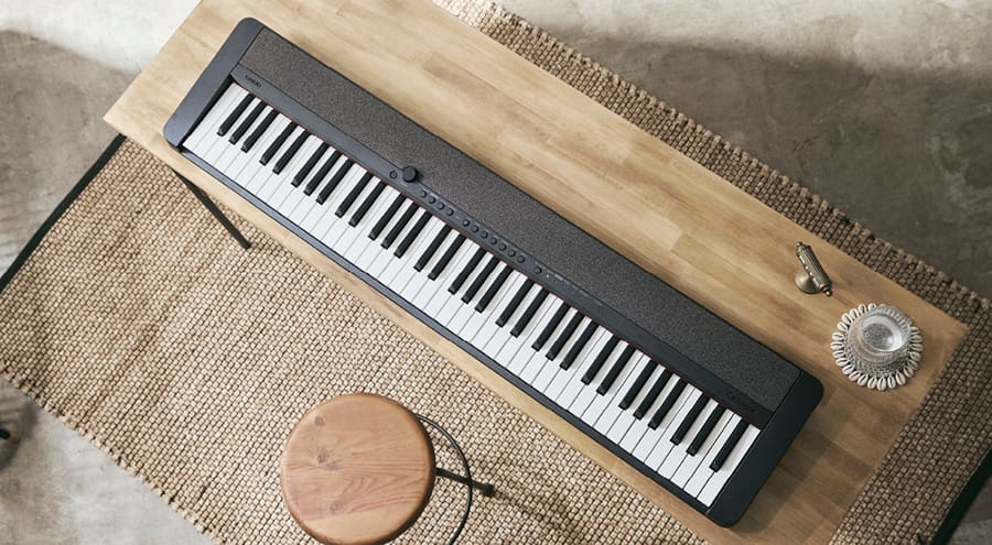 Vue d'en haut d'un piano numérique CT-S1-76 noir posé sur une table en bois