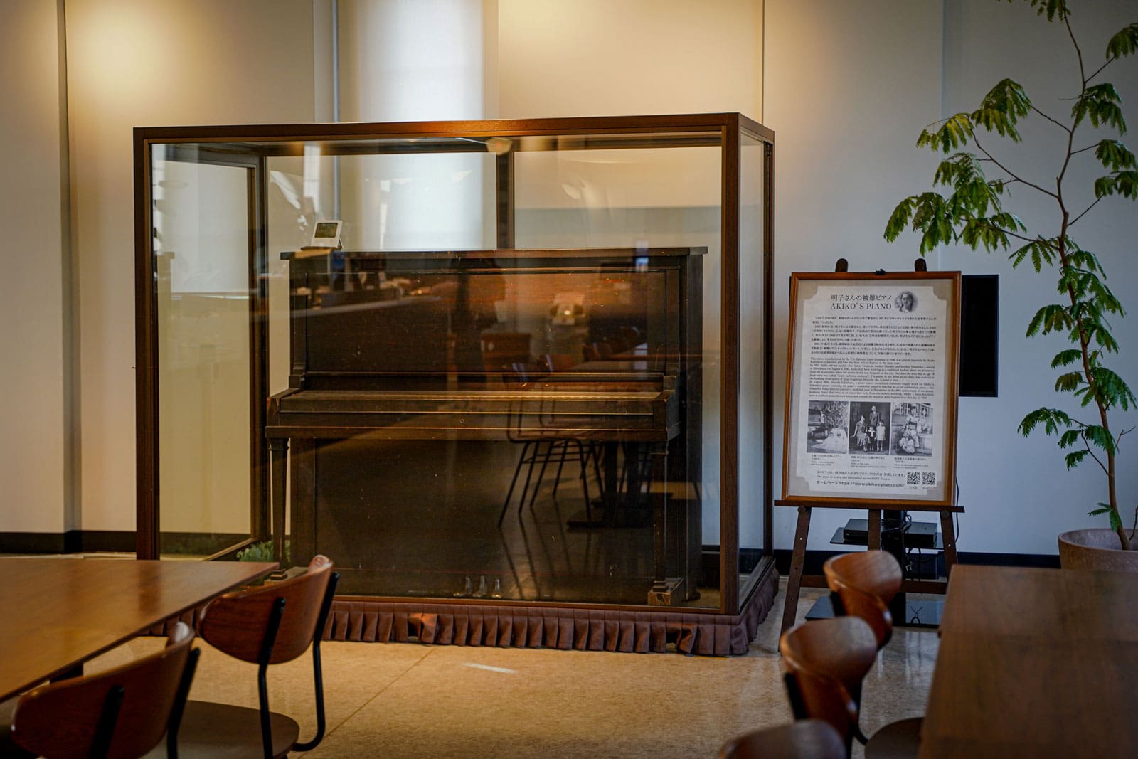 Le piano d'Akiko derrière une vitrine de verre dans un musée.