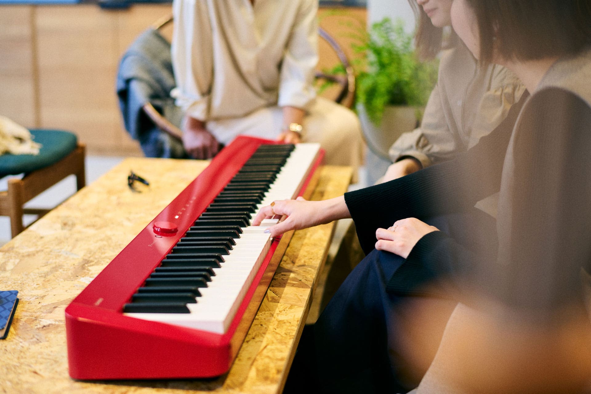 Marie Hashimoto joue sur le clavier rouge PX-S1100 posé sur une table.