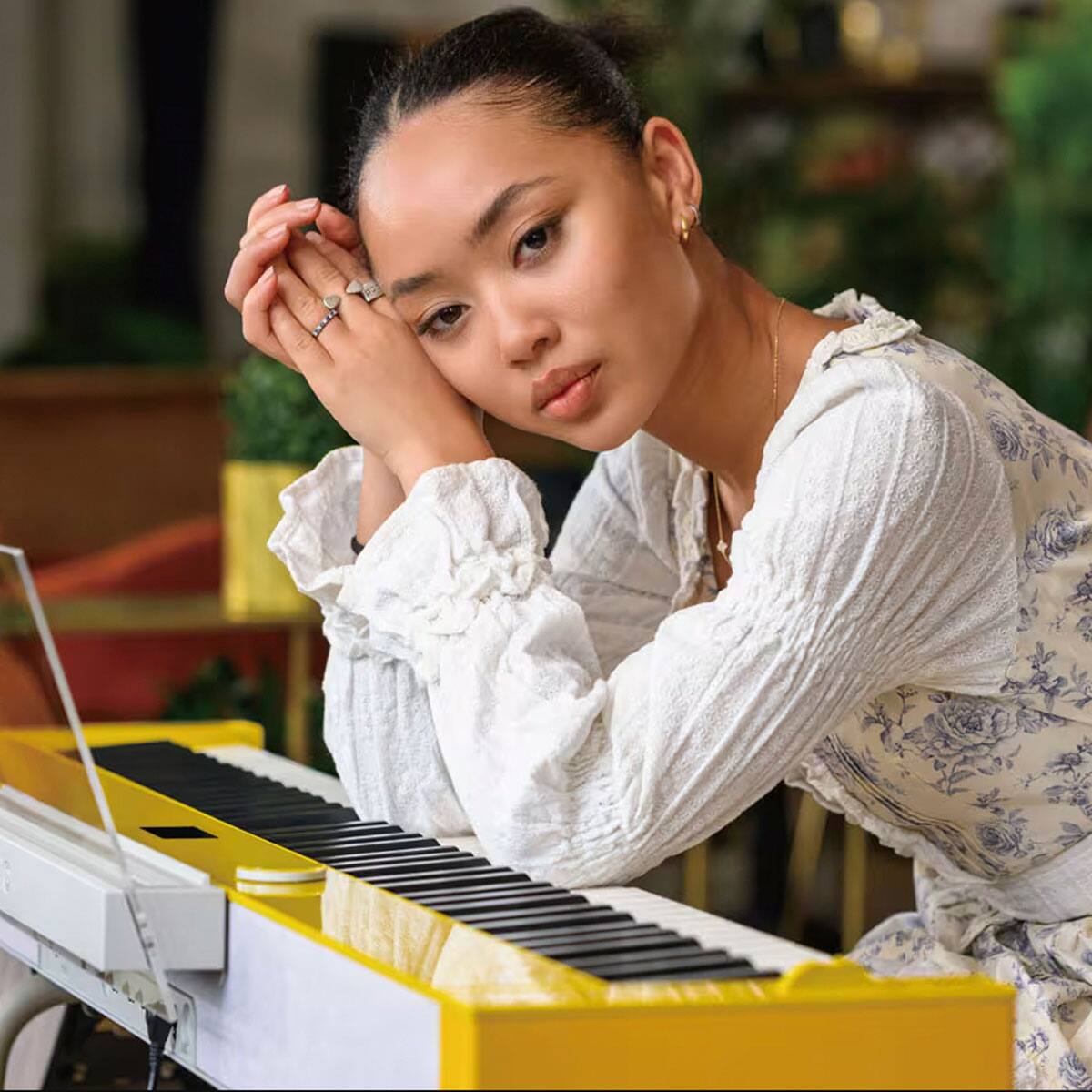 Une femme s’appuie sur le PX-S7000 jaune devant elle et regarde l’objectif.