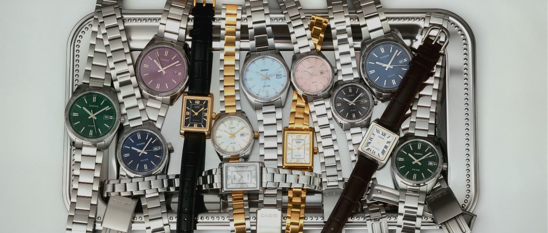 Plusieurs montres de la collection Timeless disposées sur un plateau argenté.