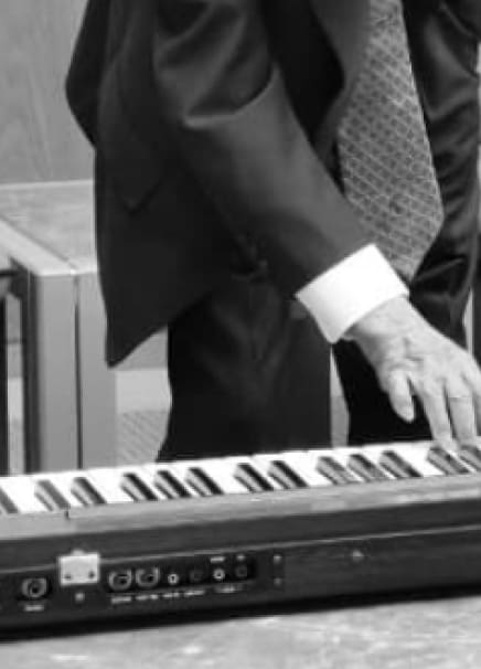 Gambar tangan seseorang sedang memainkan piano