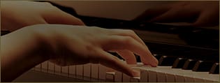 Primo piano delle mani che suonano un pianoforte digitale, l'immagine ti porta ai modelli Grand Hybrid.