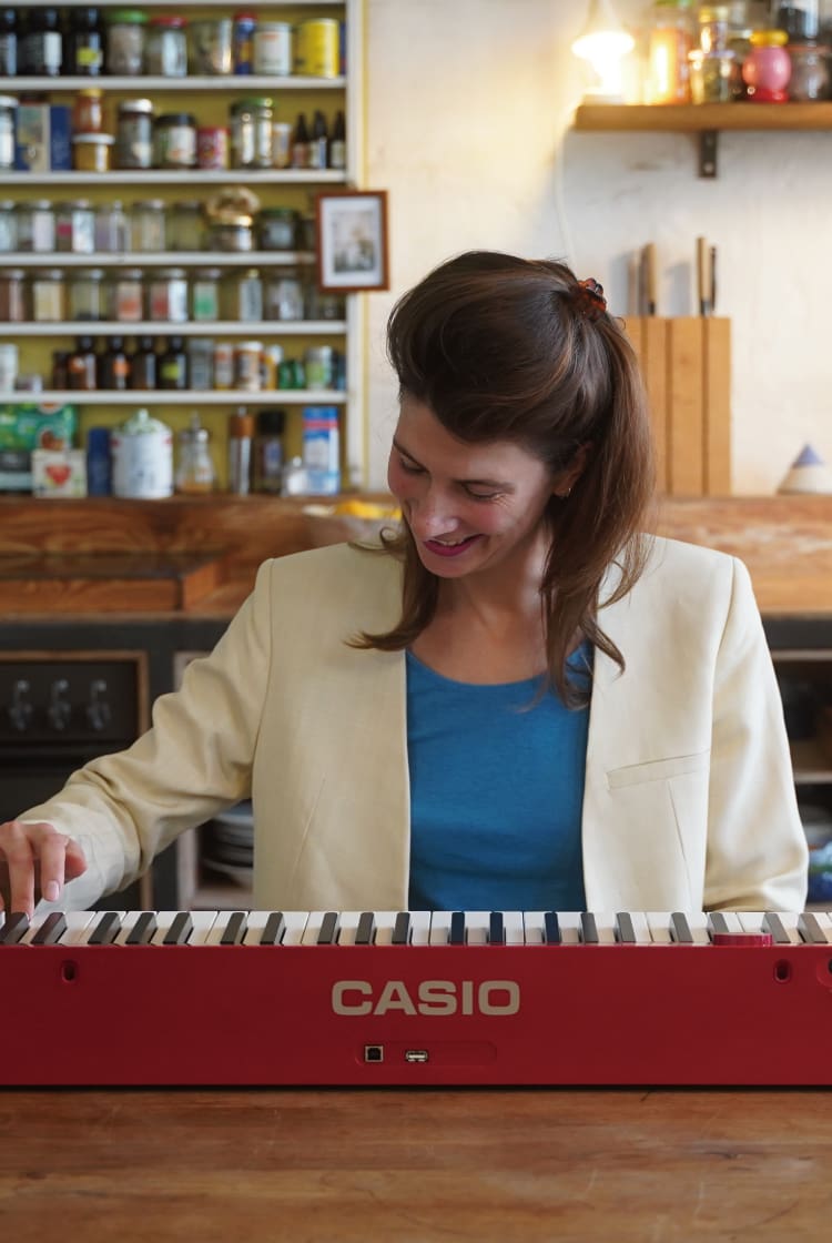 Lea Kissing suona il suo pianoforte digitale Privia rosso. L'immagine rimanda alla sua pagina “Life with Privia”.