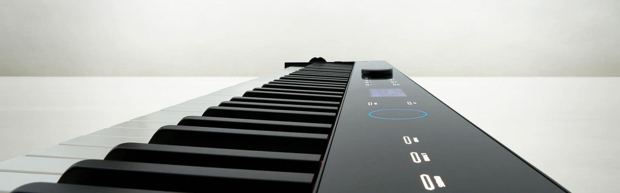 Primo piano dell'interfaccia utente piatta con comandi touch. Tasti di un pianoforte digitale Privia PX-S7000. Il testo completa l'immagine: “PX-S7000/PX-S6000 Analisi completa”