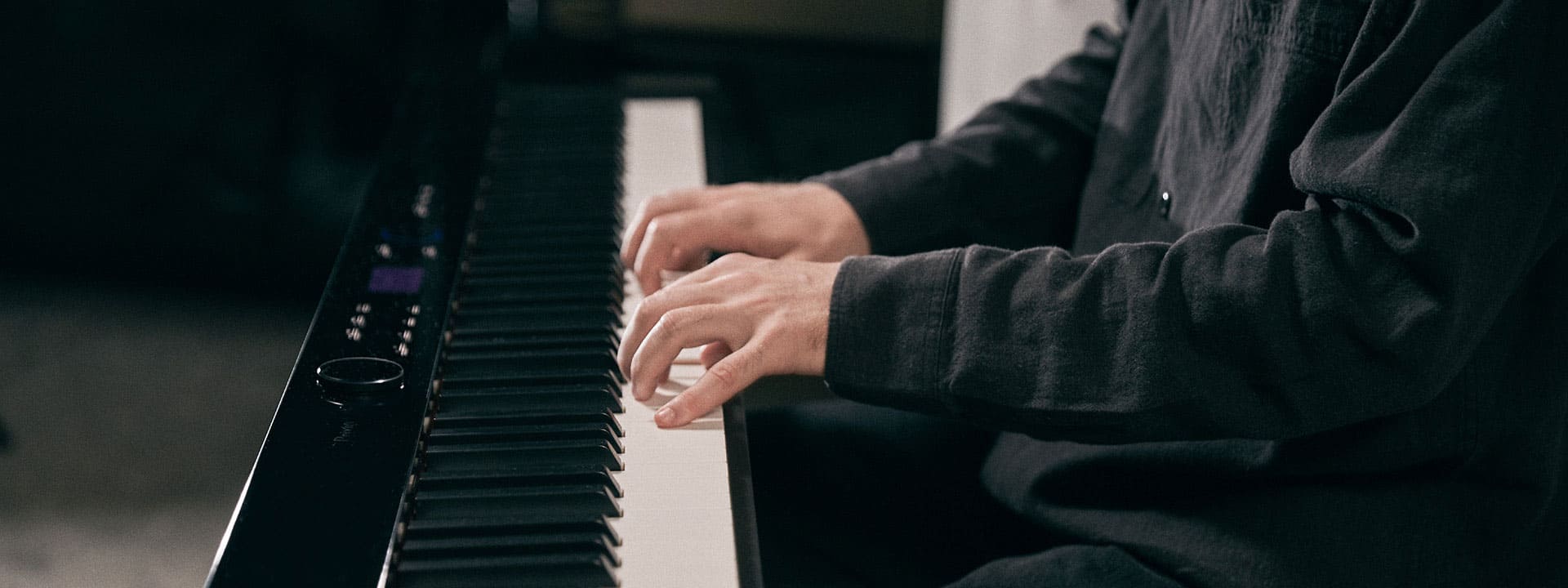 Primo piano delle mani che suonano il pianoforte