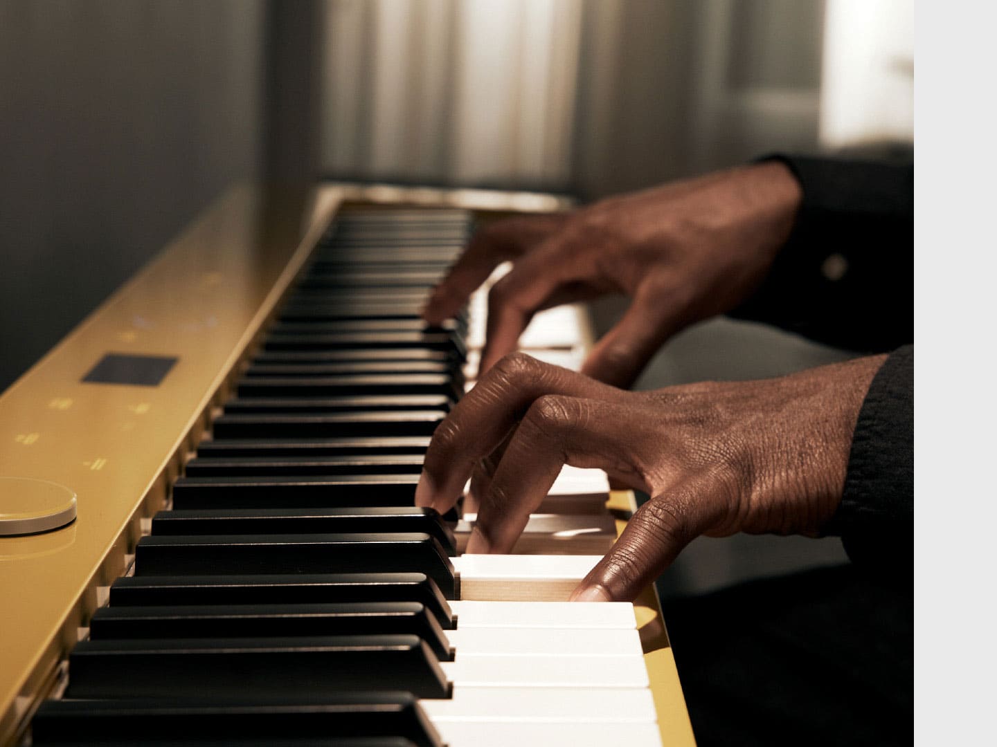 Primo piano delle mani che premono con forza i tasti di un pianoforte digitale