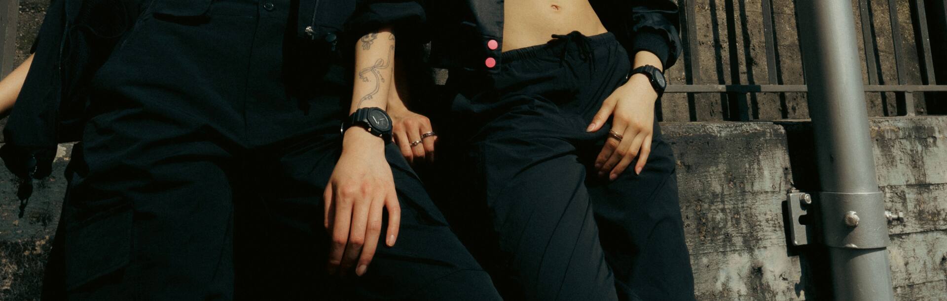 Due donne vestite di nero indossano gli orologi da polso neri GA-2100-1A1 e GMA-P2100BB-1A