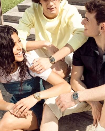 Tre persone sedute su una scala indossano diversi modelli della serie Casio Vintage A168.