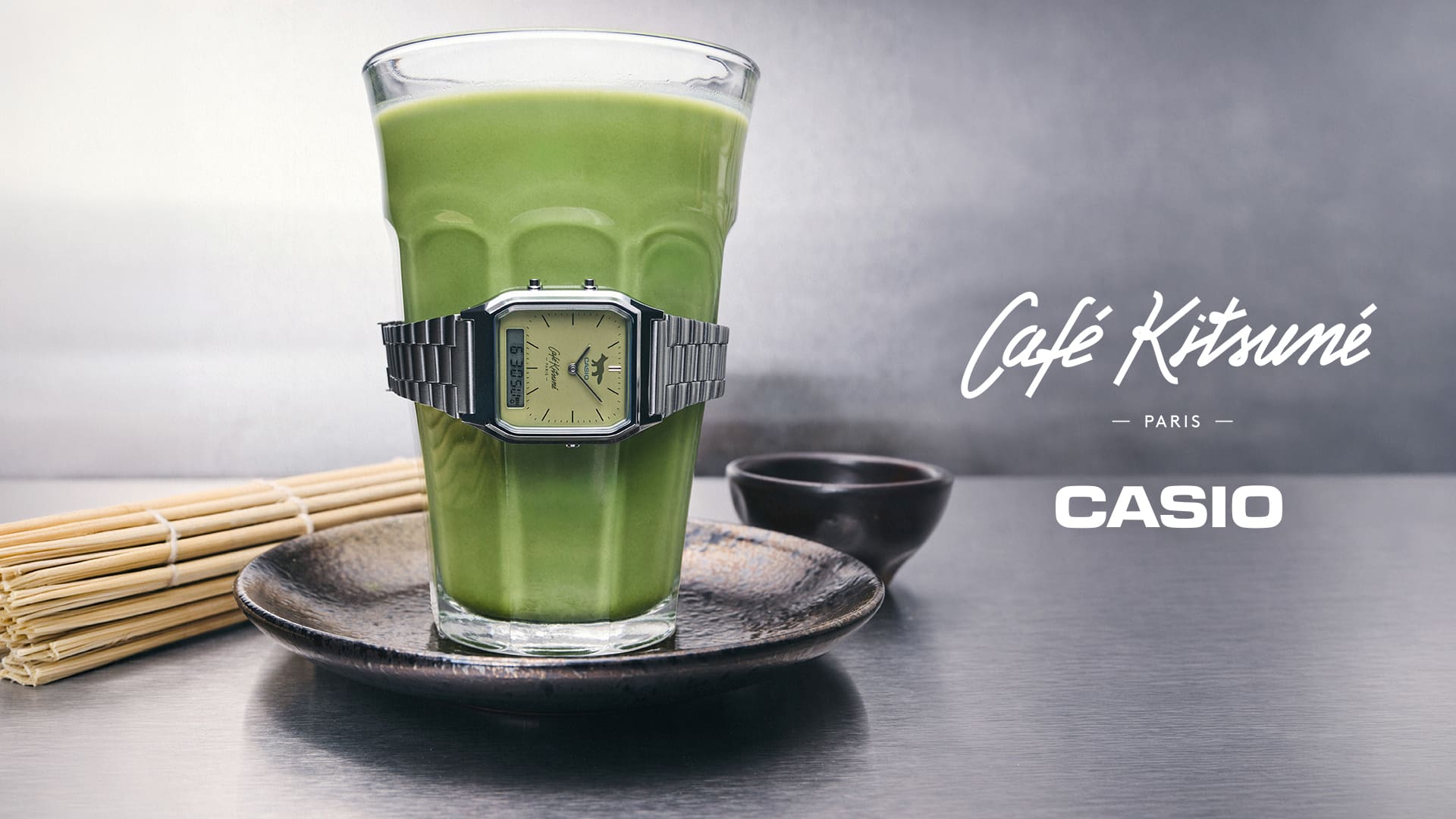 抹茶ドリンクのグラスに巻き付けられたCASIO × Café Kitsunéコラボ腕時計AQ-230ECK-3Aのメインビジュアル