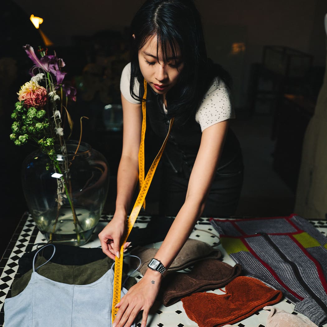 A woman measures different fabrics, the analogue wristwatch AW230A in silver can be seen on her wrist