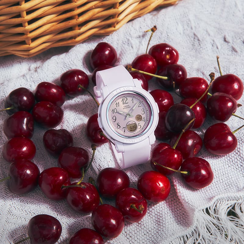 Close-up of a BGA-290SA-6A watch with cherries in the background