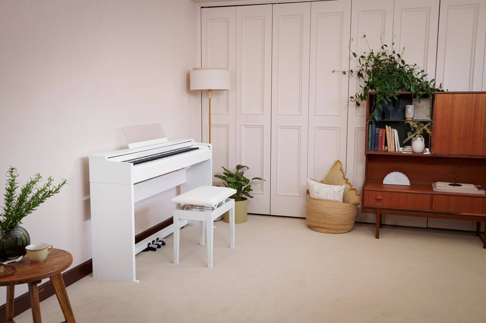 The white CELVIANO AP-S200 on a light-coloured floor in a room with dark wood furniture and plants.