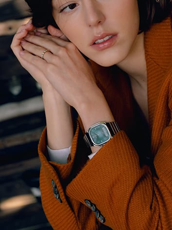 De zilveren Casio Vintage AQ-240E-3A met turquoise wijzerplaat om de pols van een vrouw