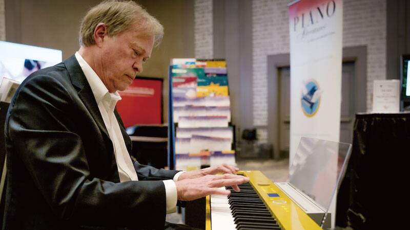 Randall Faber zit aan de gele Privia PX-S7000HM en speelt.