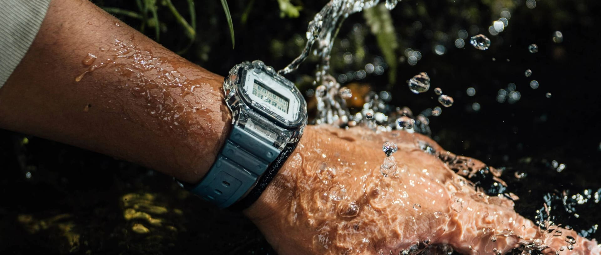 Een man houdt zijn pols onder water en draagt een waterbestendig CASIO horloge