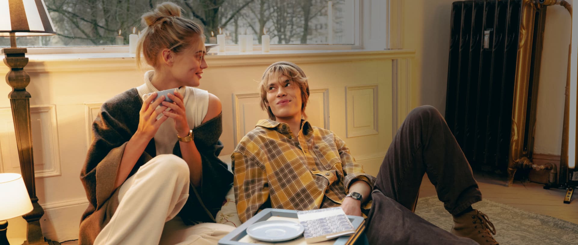 Een koppel zit op de grond in een flat en kijkt elkaar verliefd in de ogen