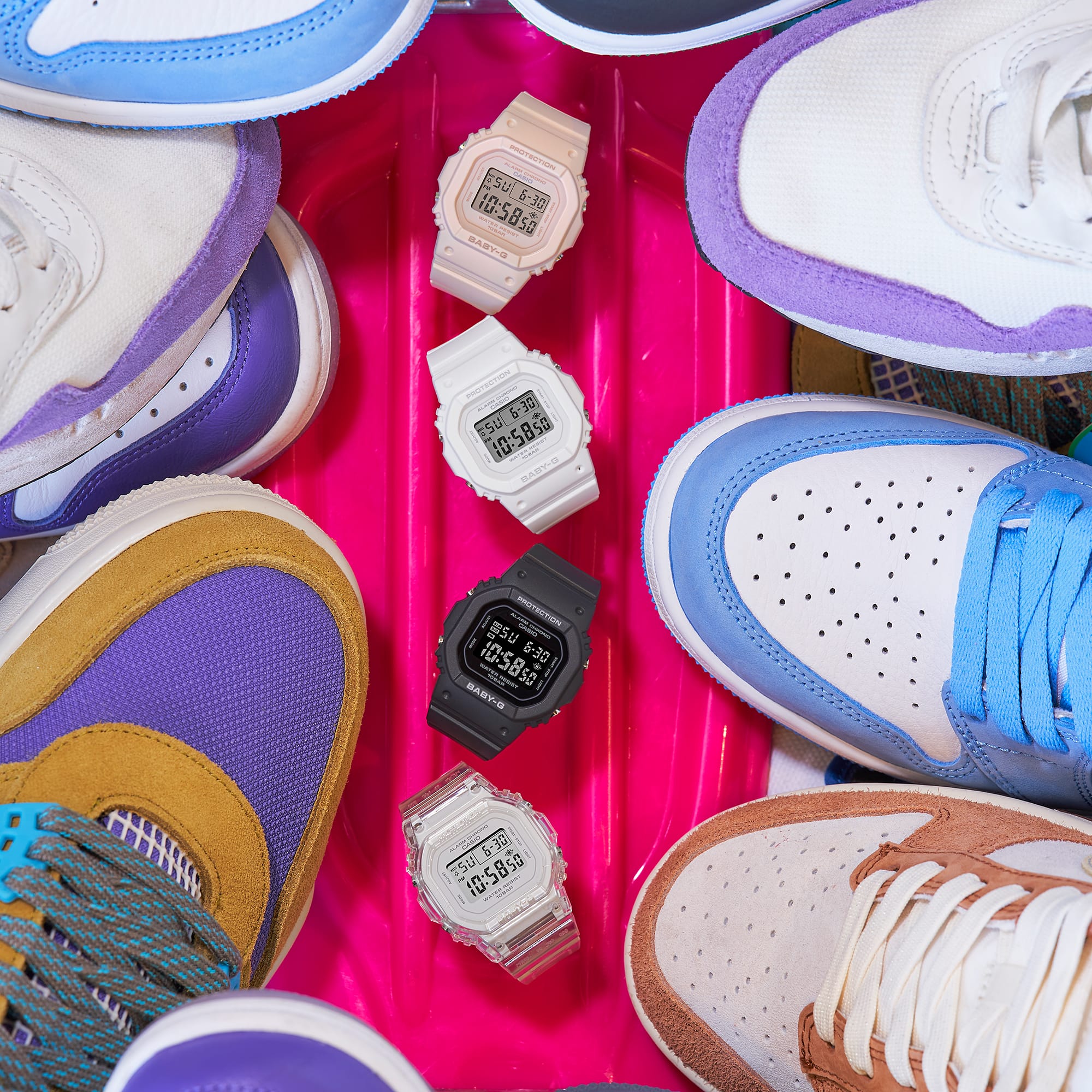 De verschillende kleurenmodellen van de BGD-565-serie omlijst door kleurrijke sneakers. De afbeelding linkt naar het witte BGD-565-7 polshorloge