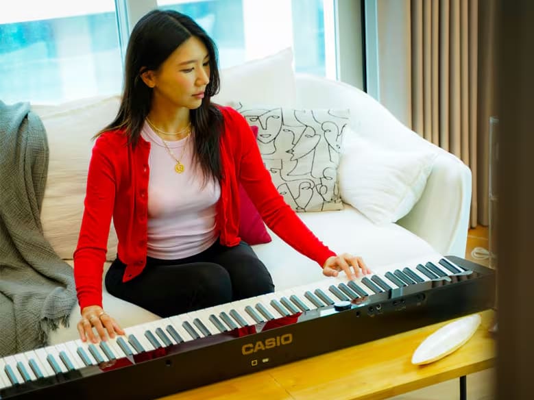An image of Jisoo Won, the brand marketer, with a Privia piano