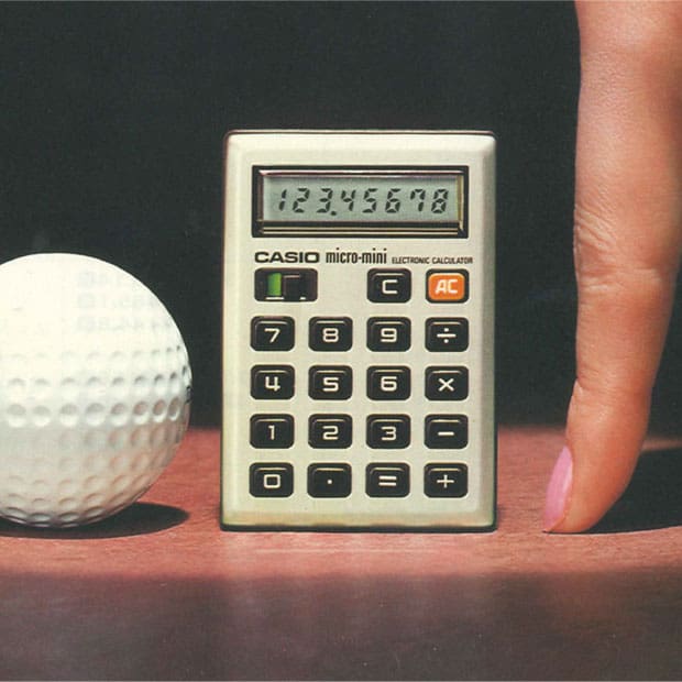O M-800 ao lado de uma bola de golfe e de um dedo