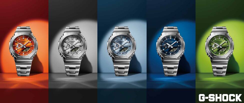 Cinco modelos G-Shock GM-2110, cada um com uma cor diferente no mostrador. Da esquerda para a direita: laranja, prateado, azul claro, azul, verde.