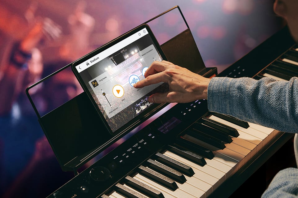 Um homem está junto ao teclado e seleciona o simulador de concerto ao vivo na aplicação.