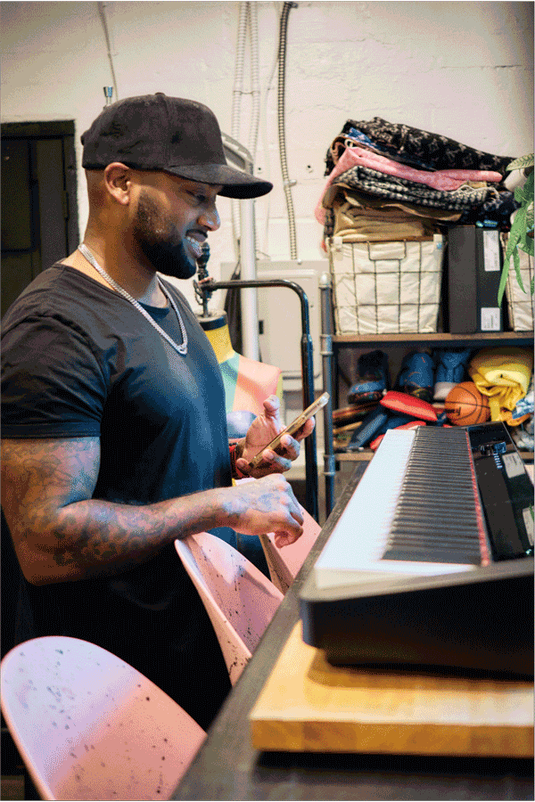 O artista Mike Farhat, de Los Angeles, em frente ao seu piano Privia preto. A imagem leva para a página Life with Privia dele.