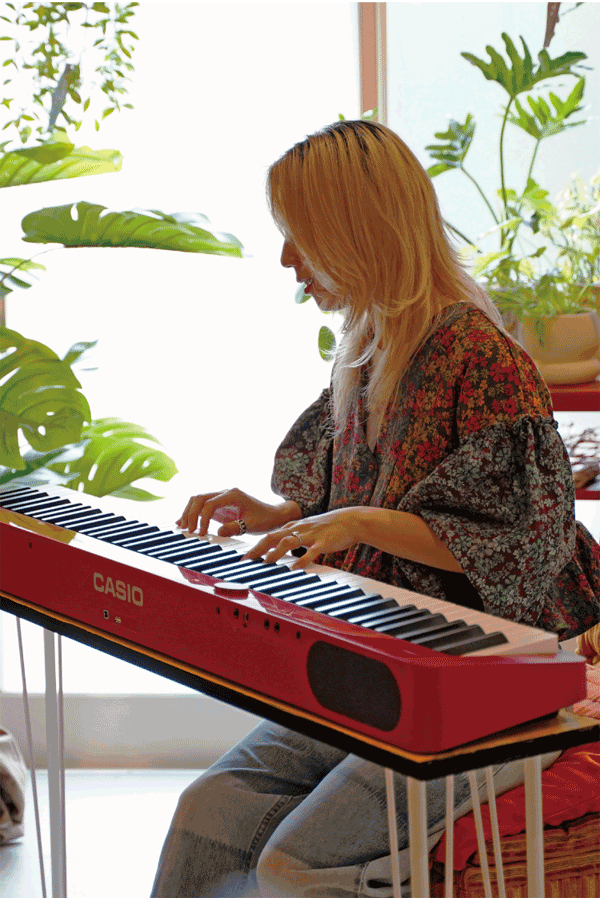 A figurinista Alex Hayano, de Tóquio, toca no seu piano Privia vermelho. A imagem tem um link para a página Life with Privia dela.