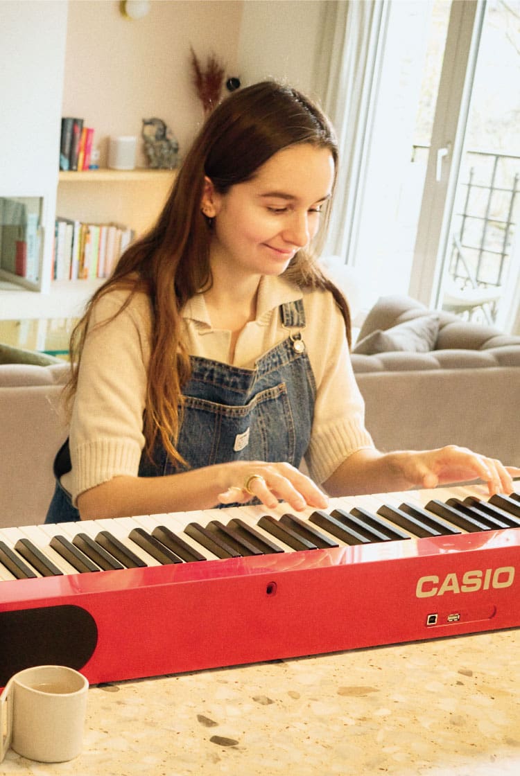 A dona de um café, Margaux Salgado, toca no seu Privia vermelho no seu apartamento em Paris. A imagem leva para a página Life with Privia dela.