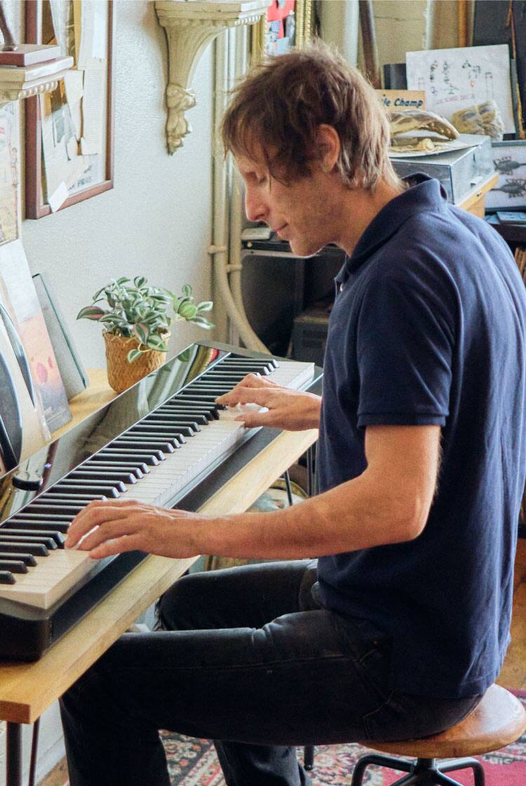 O engenheiro de som Stefen Lirakis, de Los Angeles, toca no seu piano Privia preto. A imagem leva para a página Life with Privia dele.