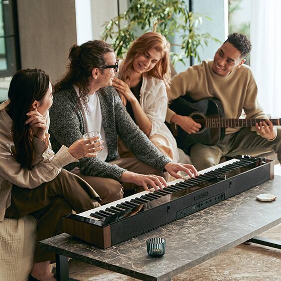 Um grupo de pessoas sentadas em frente ao PX-S6000 a tocar música.