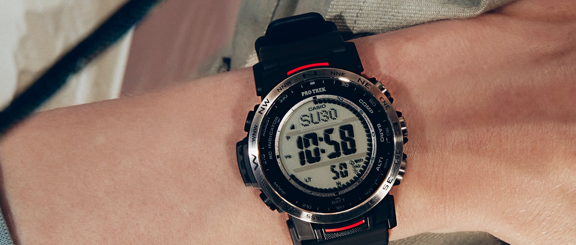 No pulso, um relógio Pro Trek PRW-35-1A com uma bracelete preta e detalhes em vermelho