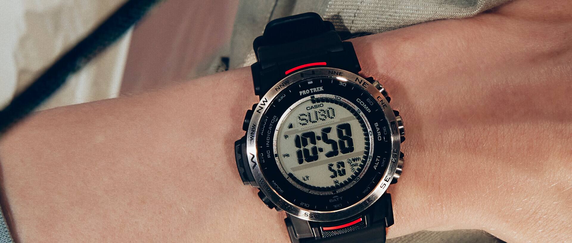 No pulso, um relógio Pro Trek PRW-35-1A com uma bracelete preta e detalhes em vermelho
