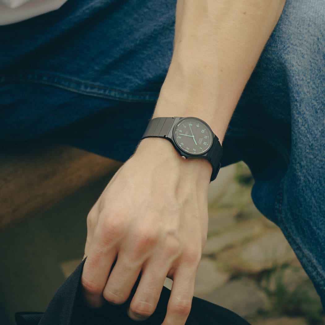 O relógio de pulso CASIO TIMELESS COLLECTION MQ-24B-8BEF com bracelete em resina de base biológica preta e mostrador analógico no pulso de um homem