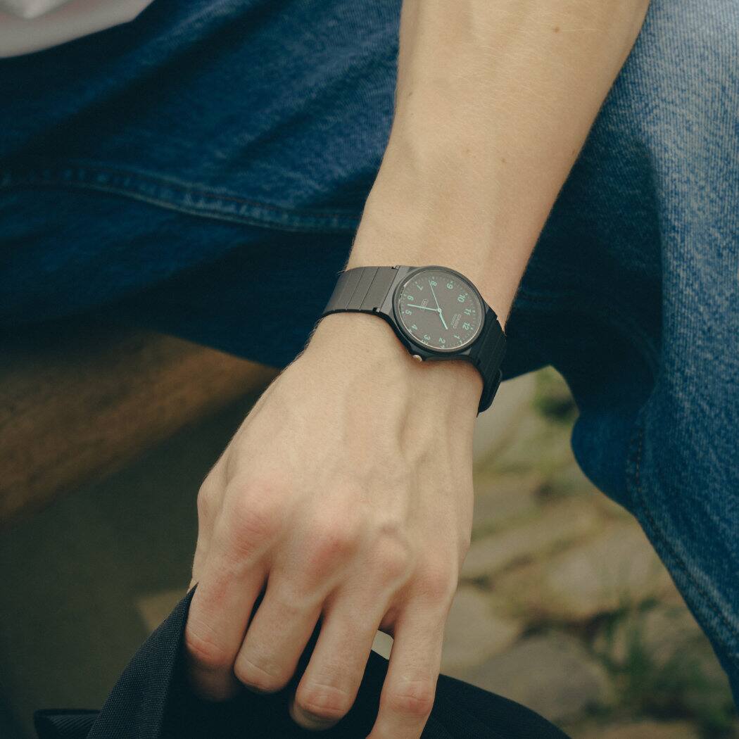 O relógio de pulso CASIO TIMELESS COLLECTION MQ-24B-8BEF com bracelete em resina de base biológica preta e mostrador analógico no pulso de um homem