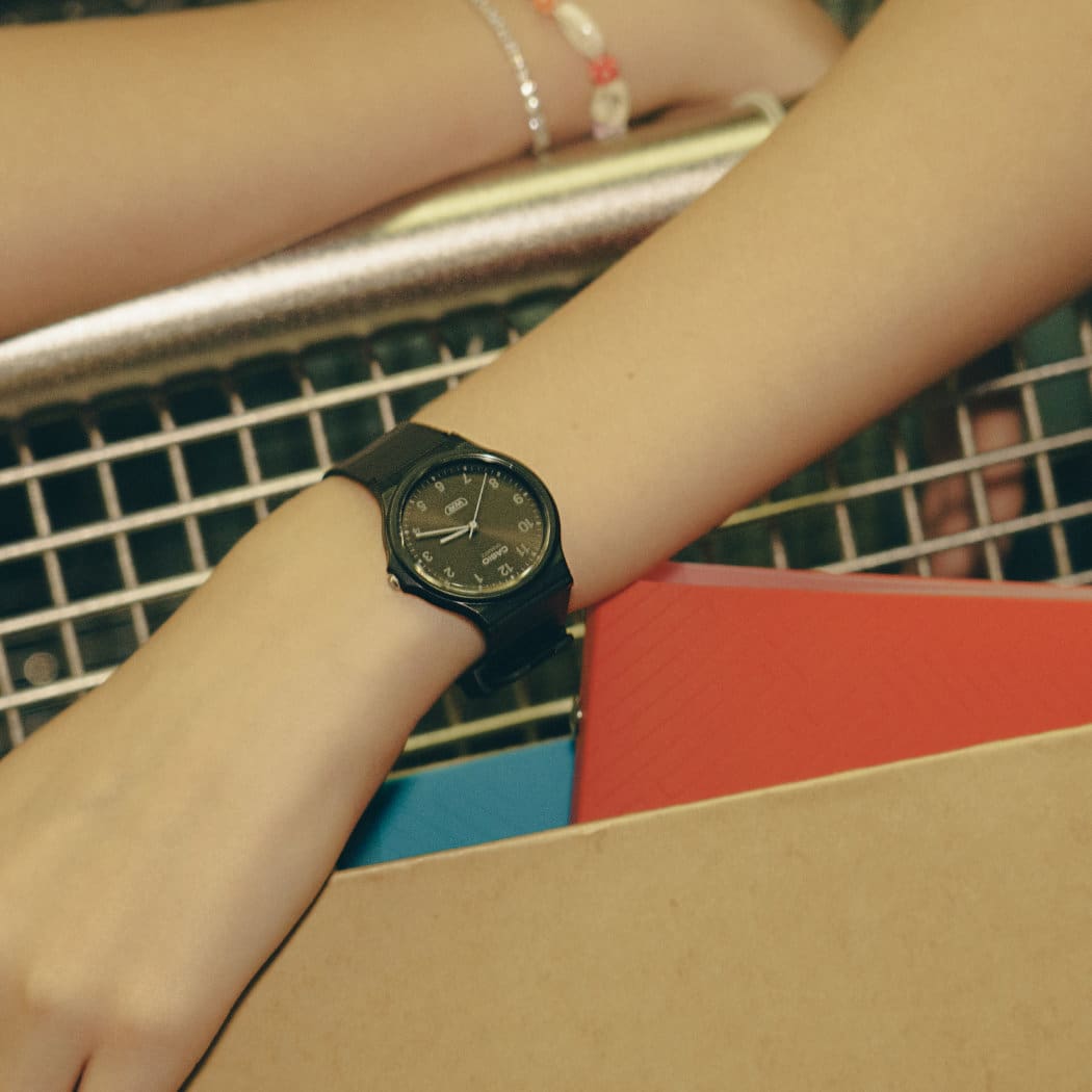 Um modelo usa o relógio Casio Timeless Collection MQ-24B-1BEF com mostrador analógico.