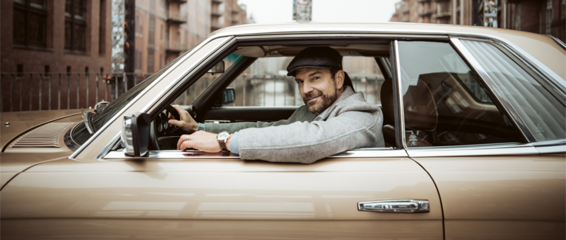 Um homem sorrisos para a câmara a partir do seu carro e usa o EFR-575L-7AEF no pulso.