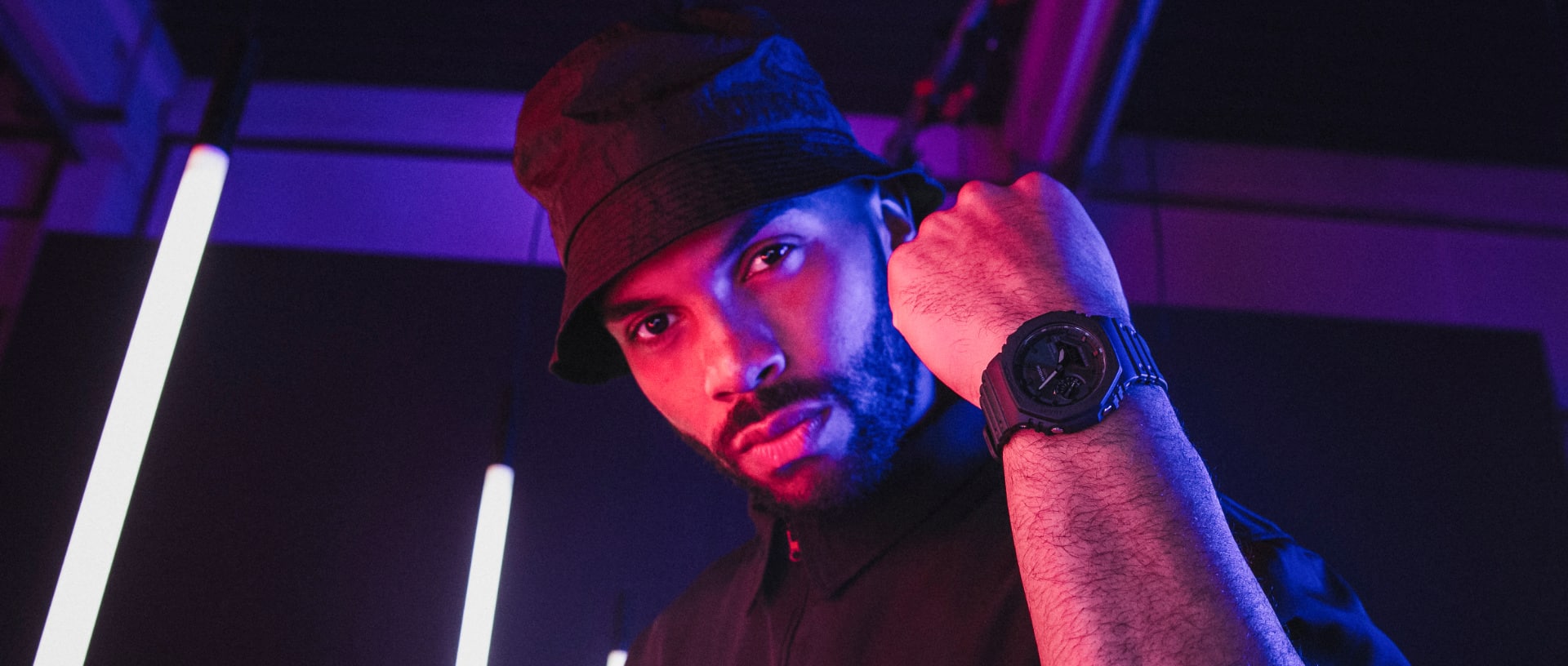Ein Mann hält sein Handgelenk hoch, an dem er die G-SHOCK Armbanduhr "GA-B2100" in schwarz trägt