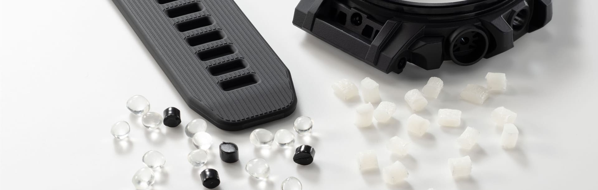 Uma bracelete preta com resina sustentável e as suas partes individuais sobre fundo branco