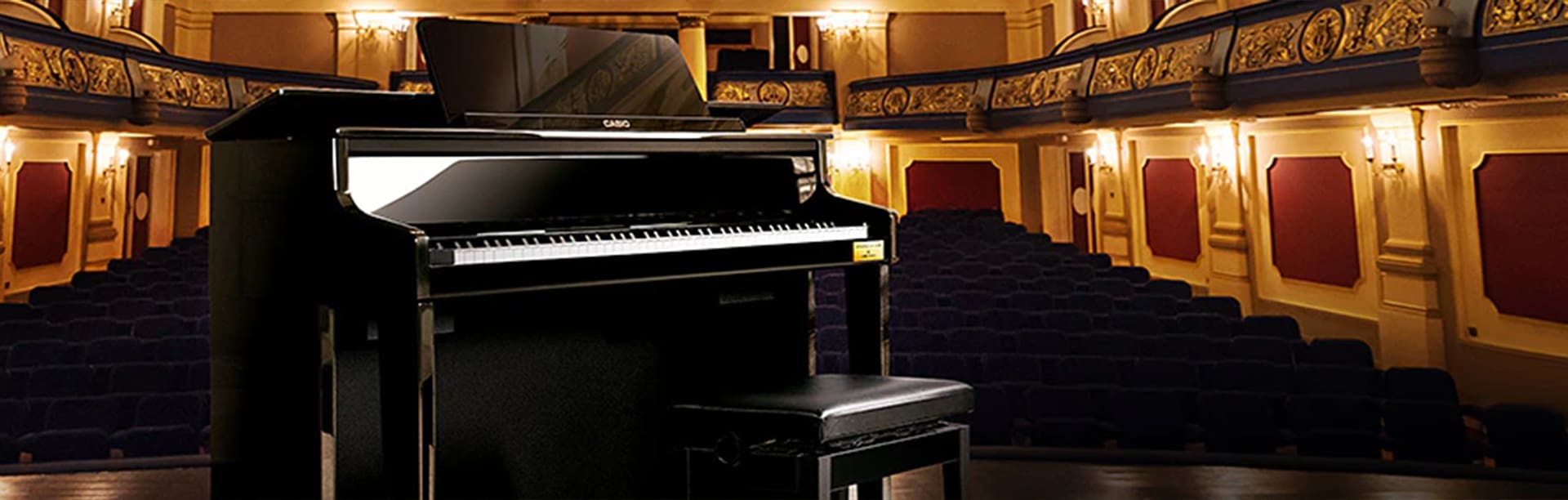 Angled front view of a Celviano GP-510 Grand Hybrid piano on stage at an ornate concert hall