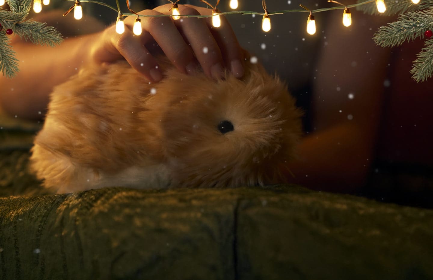 An image of a woman holding Moflin in her left hand, taking a selfie with her smartphone.